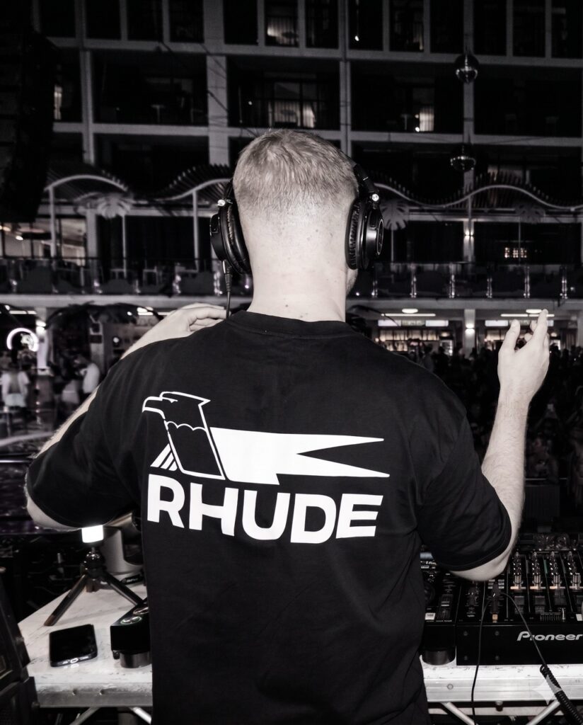 Ryan Aaron performing at a DJ booth in black and white