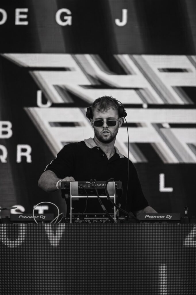 Black and white DJ booth with Ryan Aaron logo